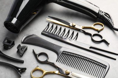 Photo of Different hairdresser's tools on grey table, above view