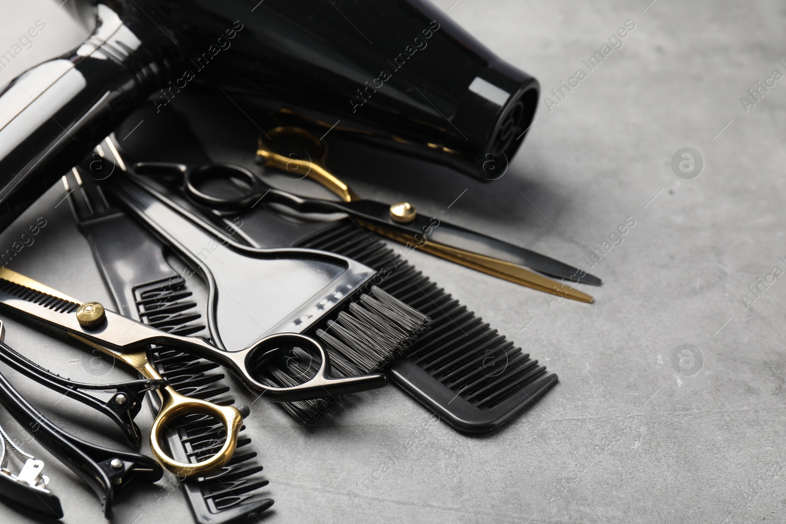 Different hairdresser's tools on grey table, closeup. Space for text Photo of Different hairdresser's tools on grey table, closeup. Space for text