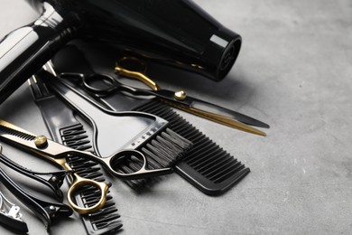 Photo of Different hairdresser's tools on grey table, closeup. Space for text
