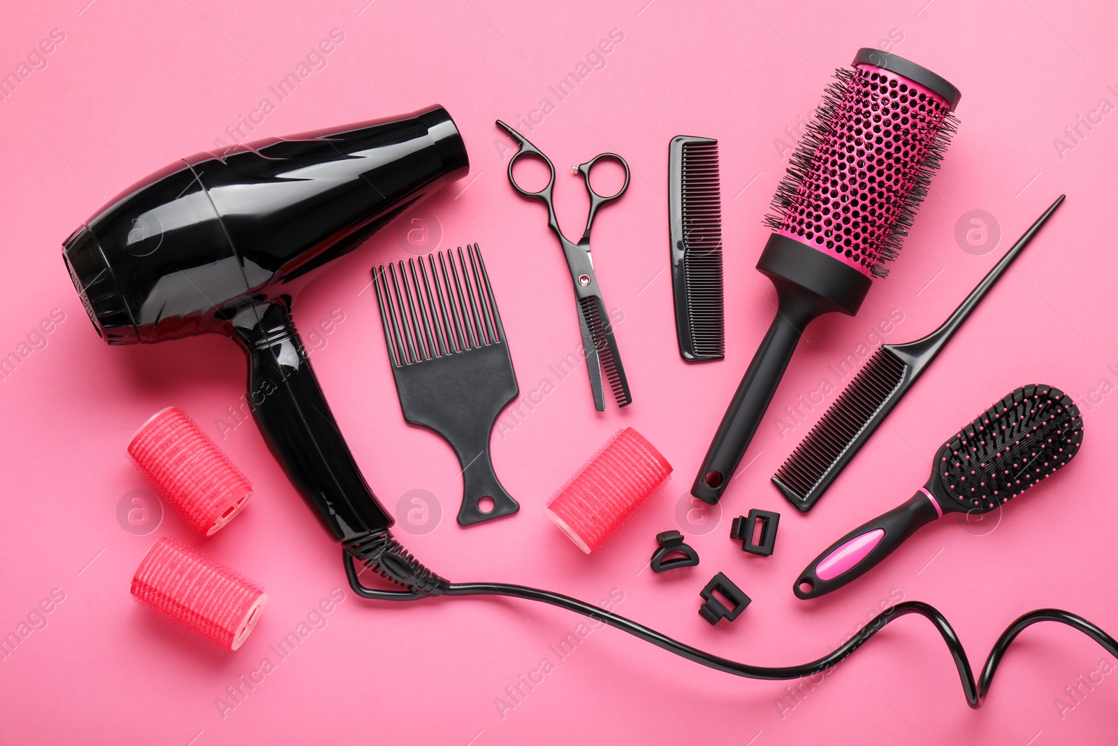 Different hairdresser's tools on pink background, flat lay Photo of Different hairdresser's tools on pink background, flat lay