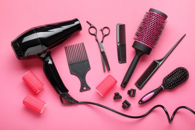 Photo of Different hairdresser's tools on pink background, flat lay