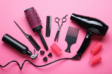 Photo of Different hairdresser's tools on pink background, flat lay