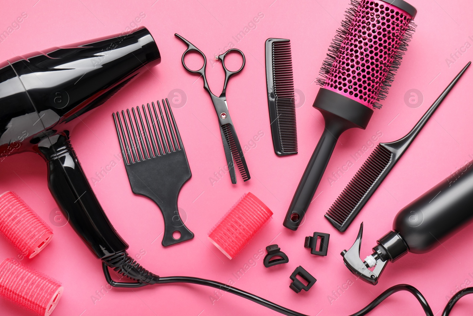 Different hairdresser's tools on pink background, flat lay Photo of Different hairdresser's tools on pink background, flat lay