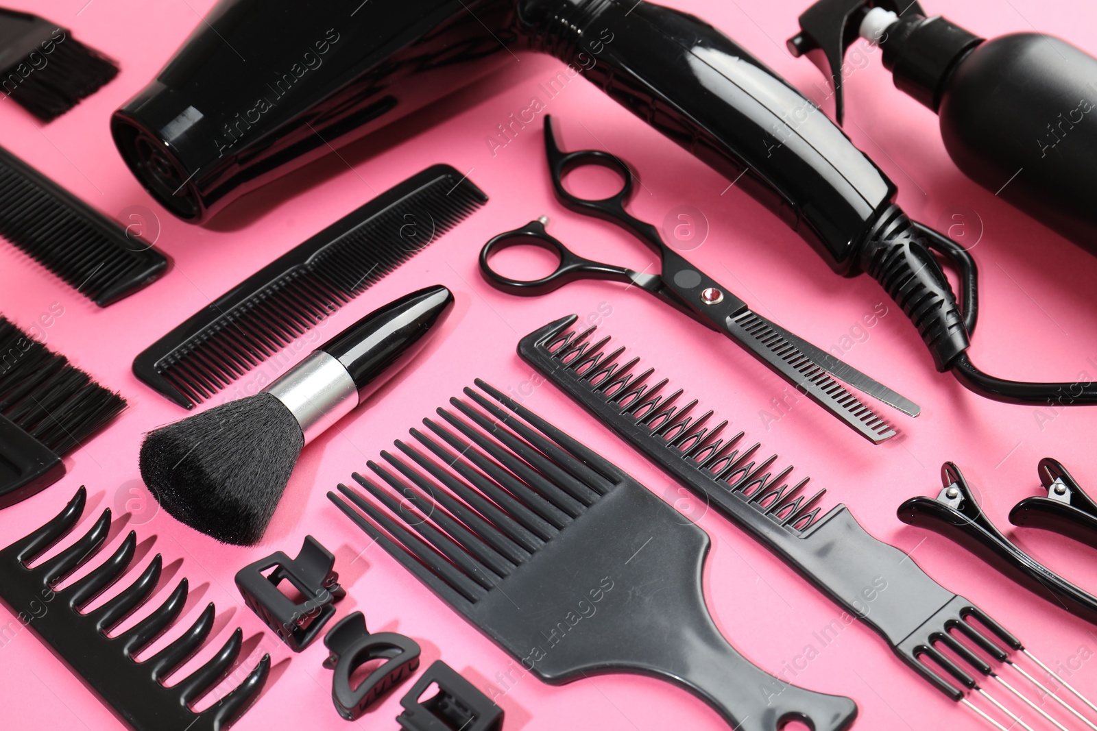 Different hairdresser's tools on pink background, above view Photo of Different hairdresser's tools on pink background, above view