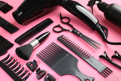 Photo of Different hairdresser's tools on pink background, above view