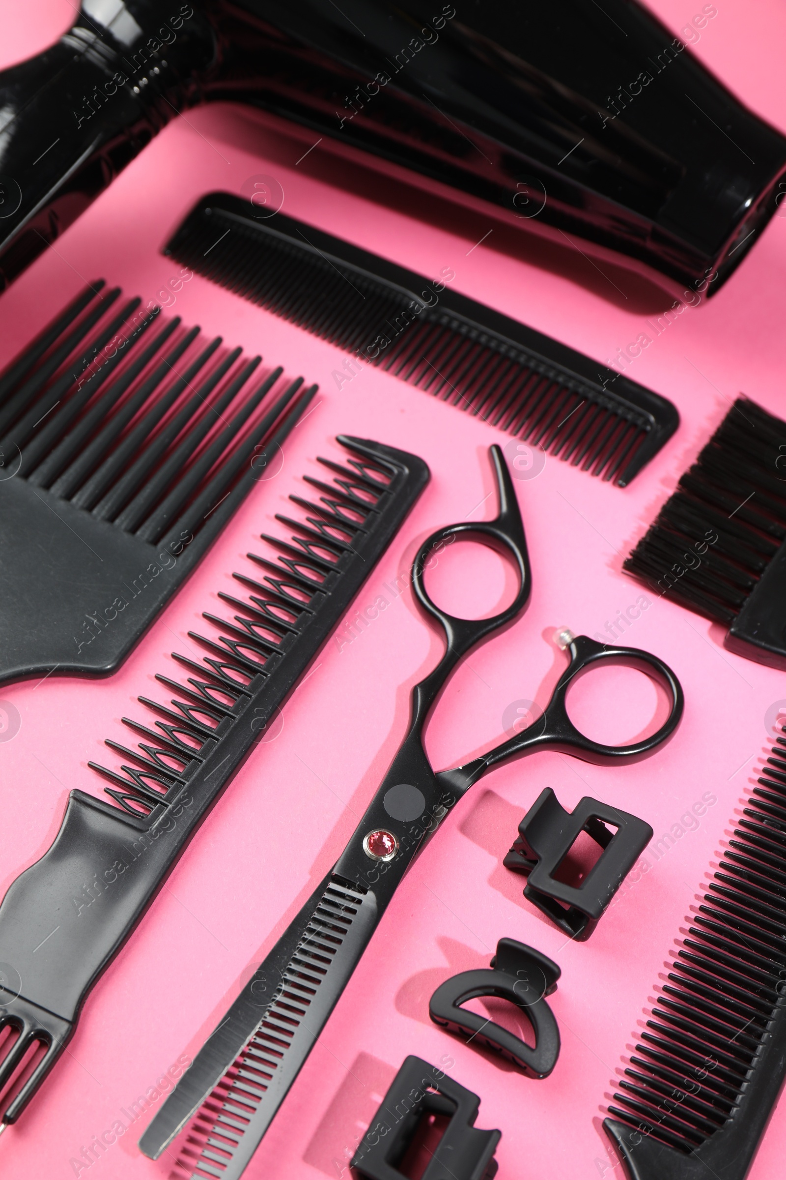 Different hairdresser's tools on pink background, above view Photo of Different hairdresser's tools on pink background, above view