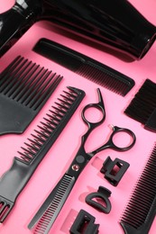 Photo of Different hairdresser's tools on pink background, above view