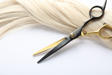 Photo of Hair lock and scissors on white background, above view