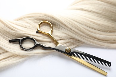 Photo of Hair lock and scissors on white background, above view