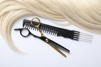 Photo of Hair lock, comb and scissors on white background, flat lay