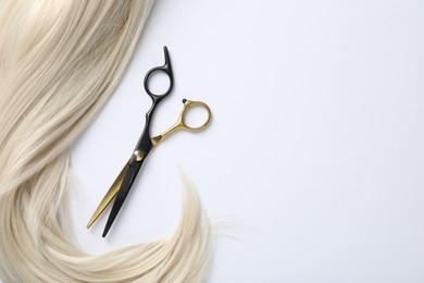 Photo of Hair lock and scissors on white background, flat lay. Space for text