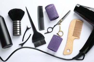Photo of Different hairdresser's tools on white background, flat lay