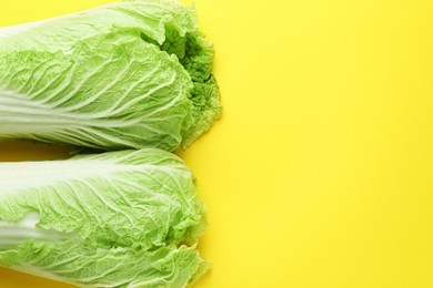 Photo of Fresh Chinese cabbages on yellow background, top view. Space for text