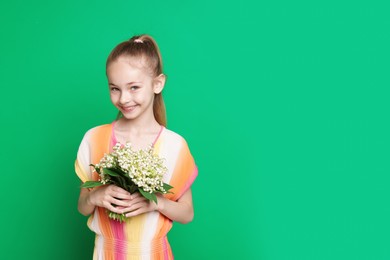 Photo of Girl with bouquet of beautiful lily-of-the-valley flowers on green background. Space for text