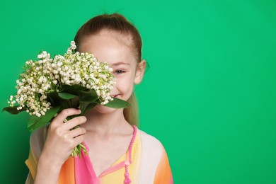 Photo of Girl with bouquet of beautiful lily-of-the-valley flowers on green background. Space for text