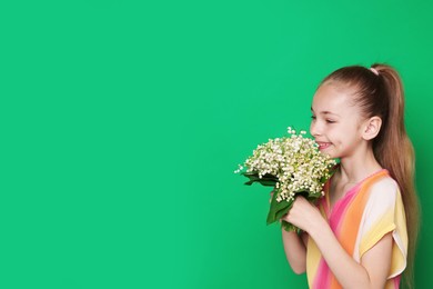 Photo of Girl with bouquet of beautiful lily-of-the-valley flowers on green background. Space for text