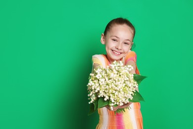 Photo of Girl with bouquet of beautiful lily-of-the-valley flowers on green background. Space for text