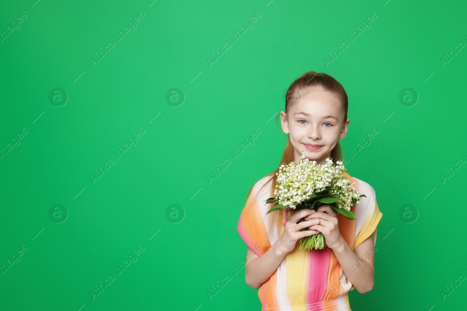 Girl with bouquet of beautiful lily-of-the-valley flowers on green background. Space for text Photo of Girl with bouquet of beautiful lily-of-the-valley flowers on green background. Space for text