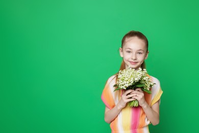 Photo of Girl with bouquet of beautiful lily-of-the-valley flowers on green background. Space for text