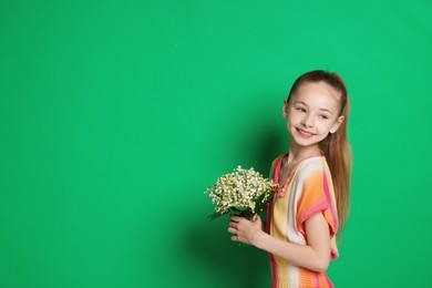 Photo of Girl with bouquet of beautiful lily-of-the-valley flowers on green background. Space for text