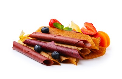 Photo of Delicious fruit leather rolls, mint and berries isolated on white