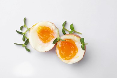 Photo of Soft boiled eggs with microgreens on white background, top view
