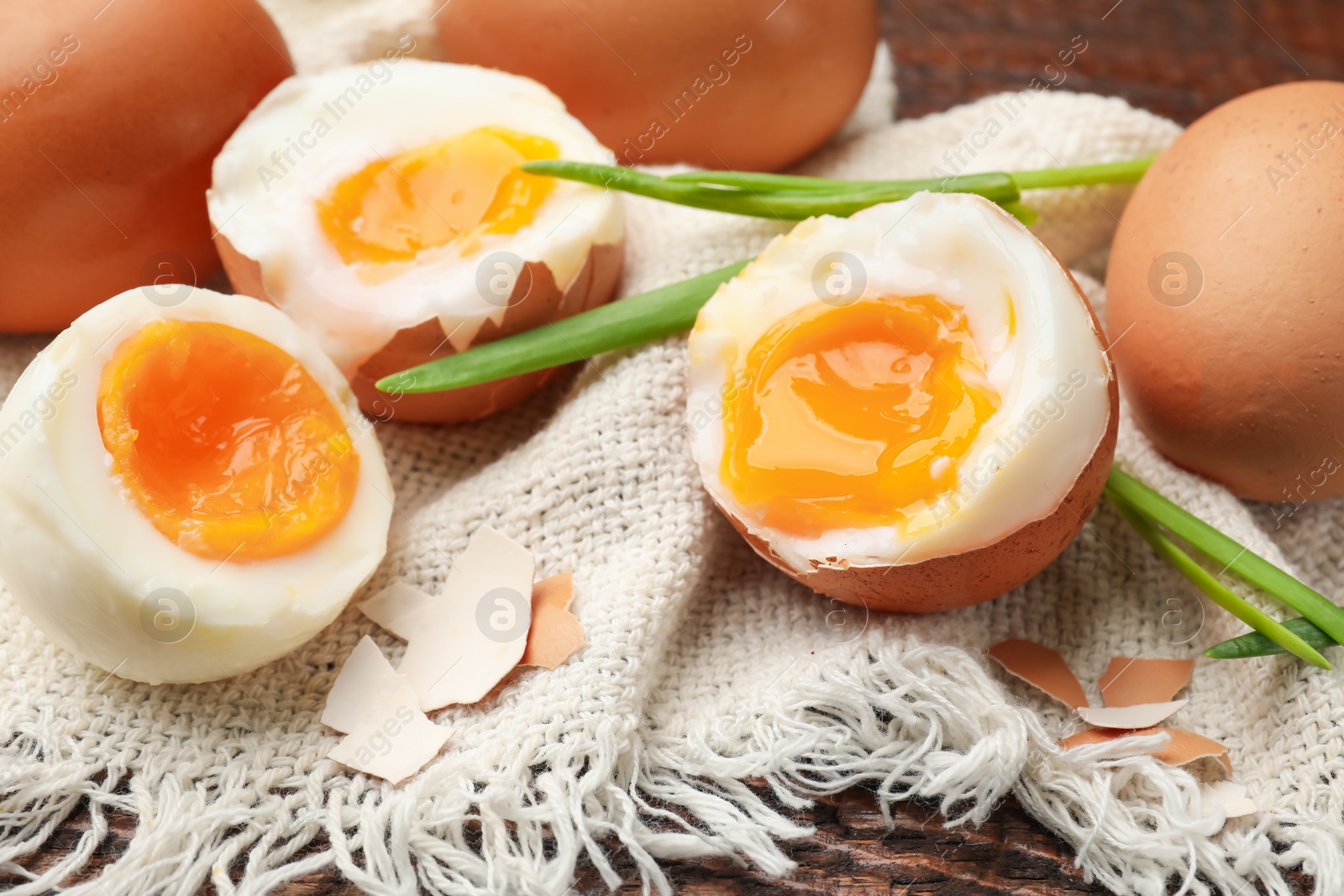 Soft boiled eggs with green onions on wooden table, closeup Photo of Soft boiled eggs with green onions on wooden table, closeup