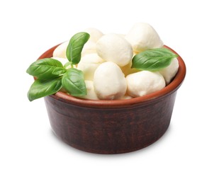 Photo of Tasty mozzarella cheese balls and basil in bowl isolated on white