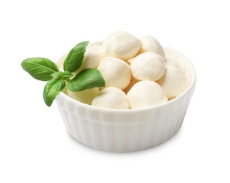 Photo of Tasty mozzarella cheese balls and basil in bowl isolated on white