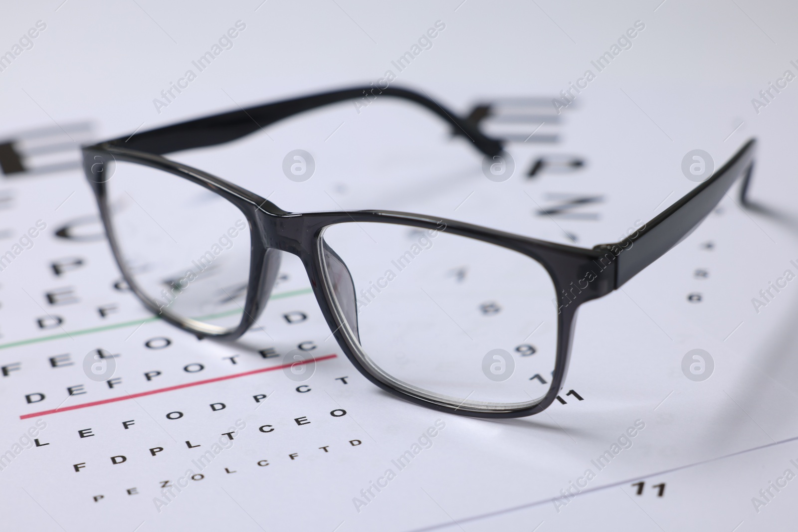 Glasses on vision test charts as background, closeup Photo of Glasses on vision test charts as background, closeup