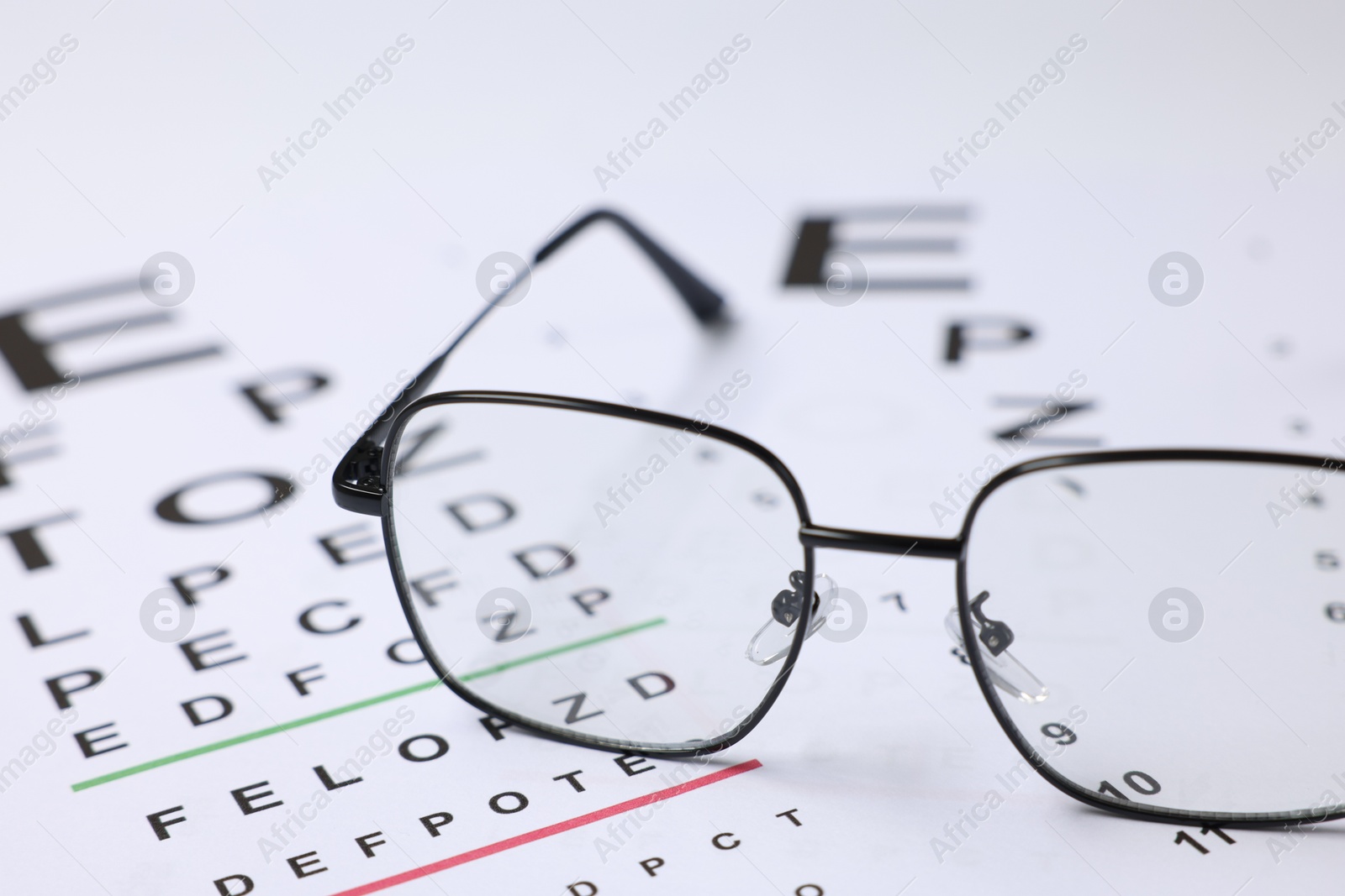 Glasses on vision test charts as background, closeup Photo of Glasses on vision test charts as background, closeup