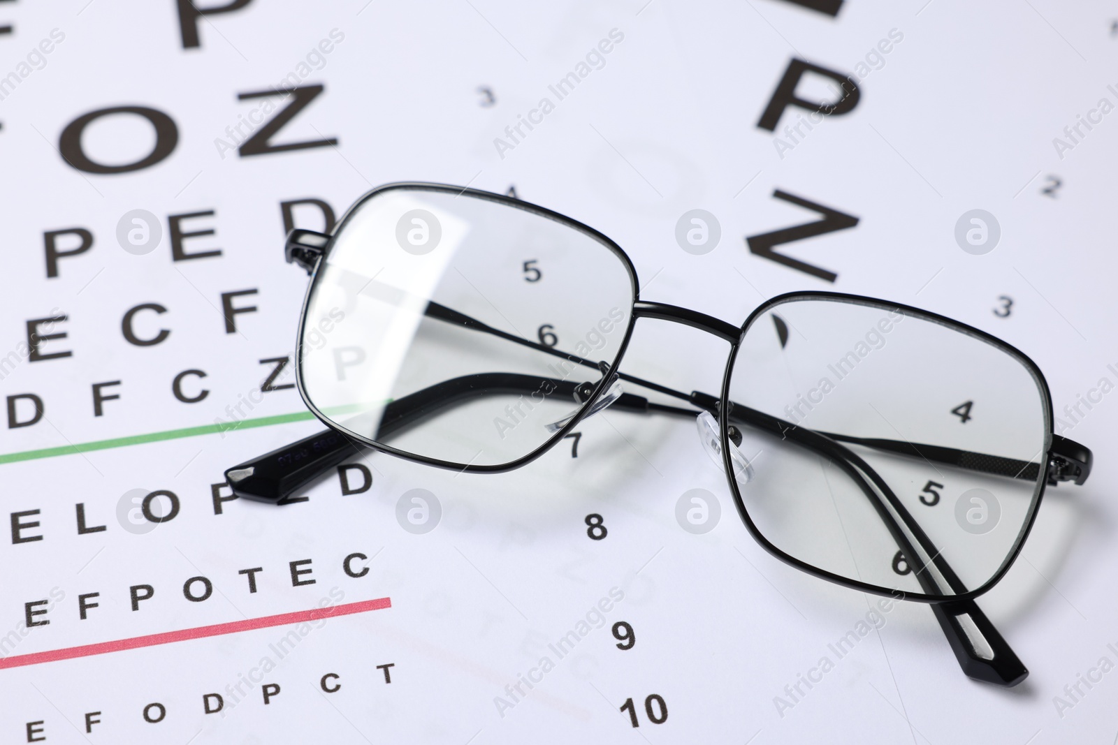 Glasses on vision test charts as background, closeup Photo of Glasses on vision test charts as background, closeup