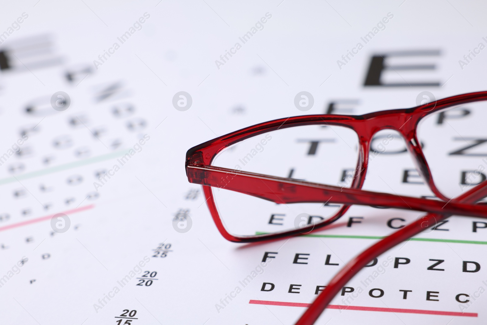 Glasses on vision test charts as background, closeup Photo of Glasses on vision test charts as background, closeup