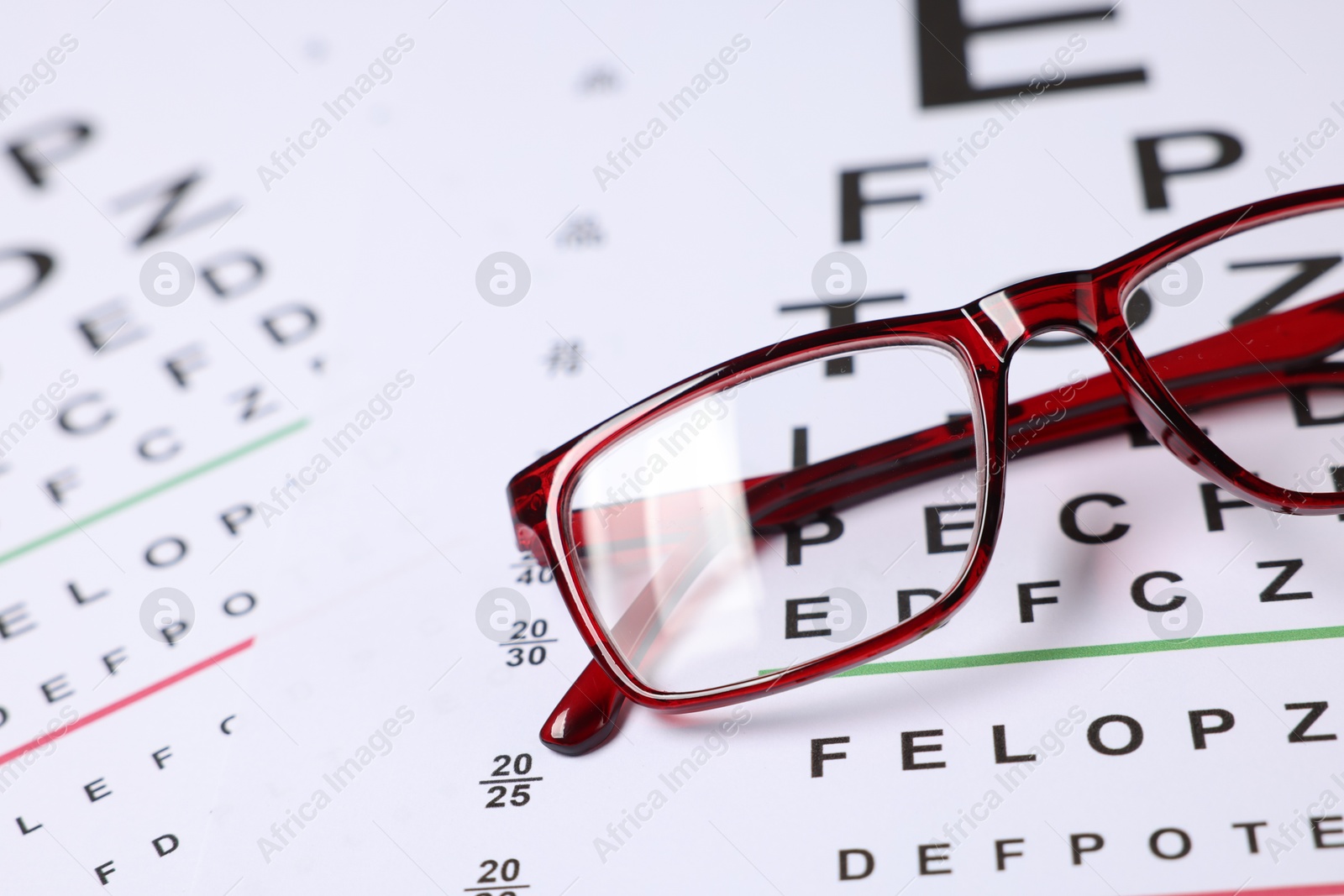 Glasses on vision test charts as background, closeup Photo of Glasses on vision test charts as background, closeup