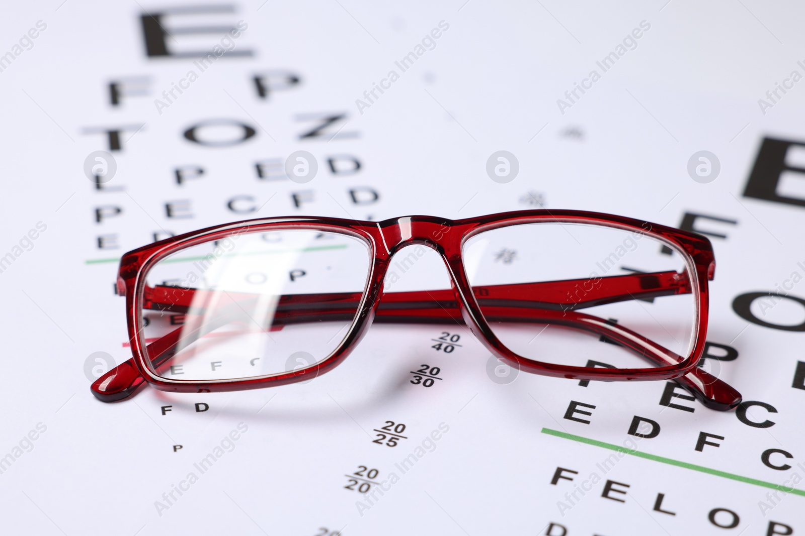 Glasses on vision test charts as background, closeup Photo of Glasses on vision test charts as background, closeup