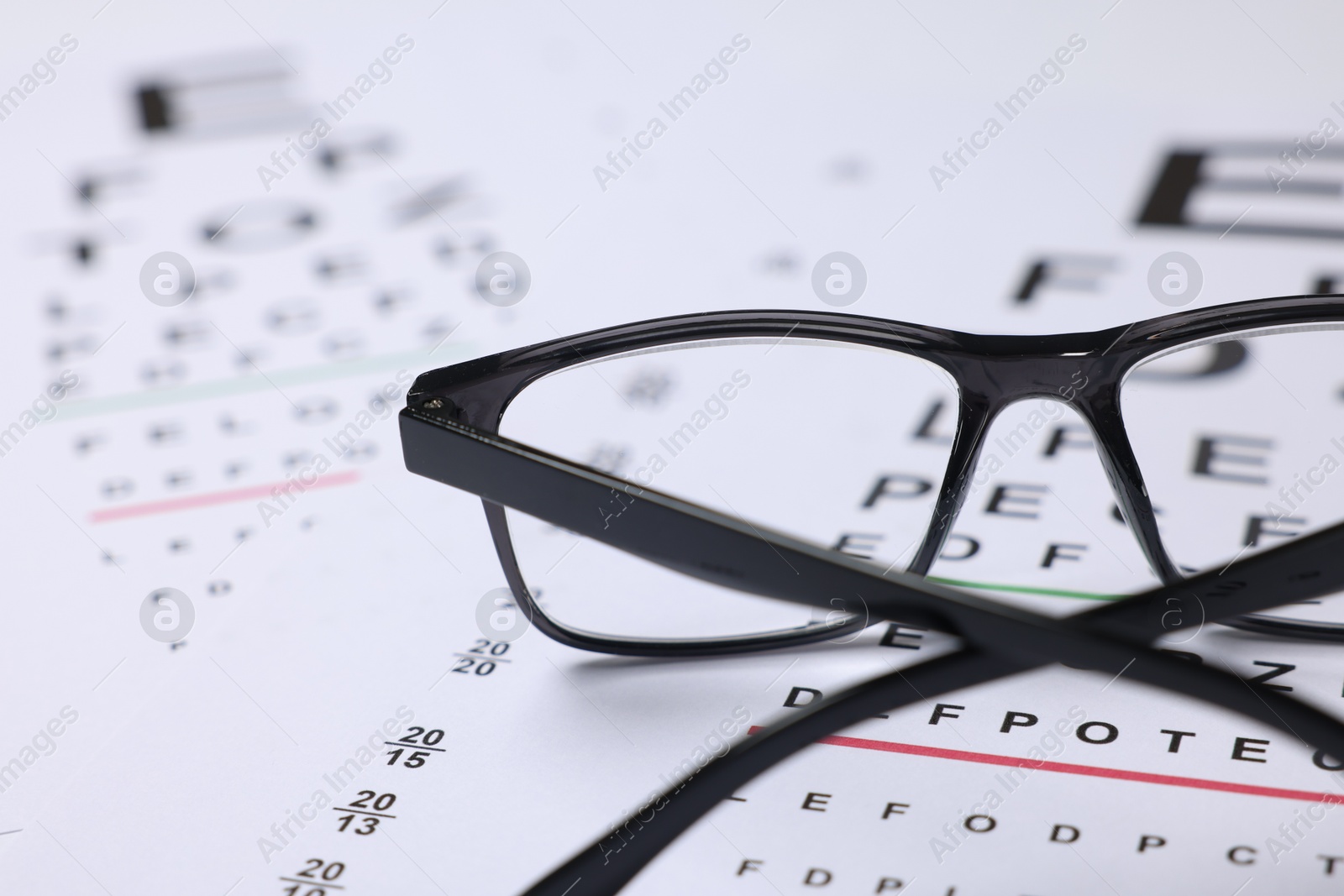 Glasses on vision test charts as background, closeup Photo of Glasses on vision test charts as background, closeup