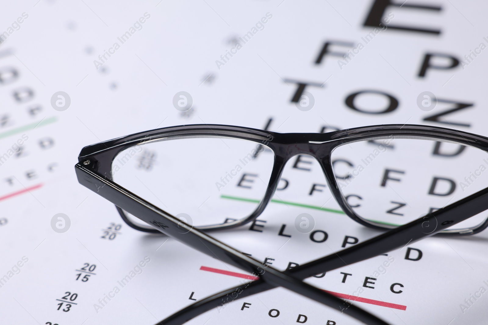 Glasses on vision test charts as background, closeup Photo of Glasses on vision test charts as background, closeup