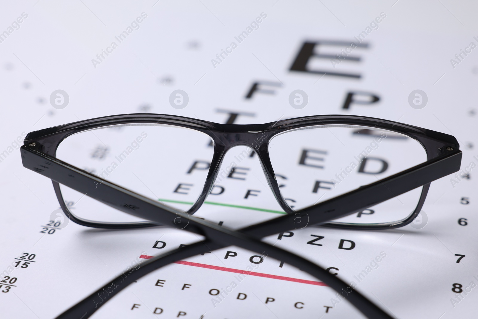Glasses on vision test charts as background, closeup Photo of Glasses on vision test charts as background, closeup