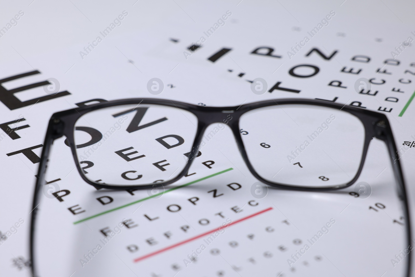 Glasses on vision test charts as background, closeup Photo of Glasses on vision test charts as background, closeup