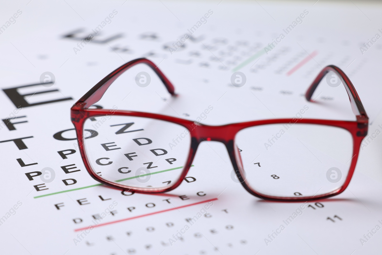 Glasses on vision test charts as background, closeup Photo of Glasses on vision test charts as background, closeup