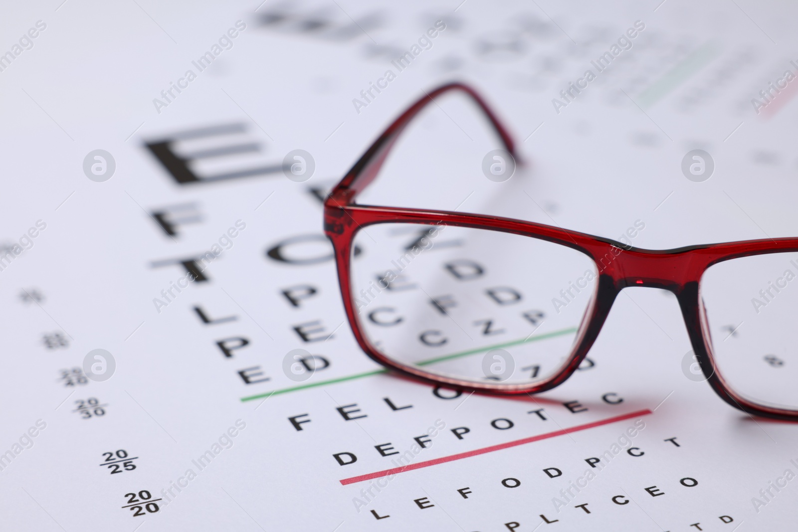 Glasses on vision test charts as background, closeup Photo of Glasses on vision test charts as background, closeup
