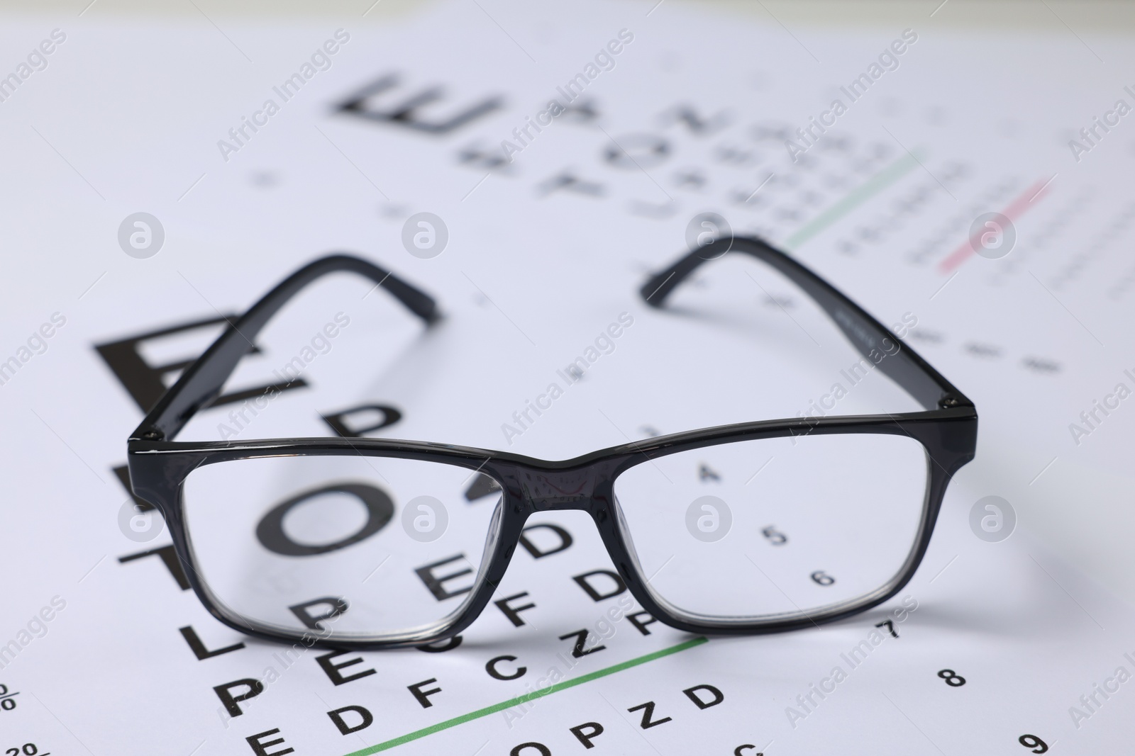 Glasses on vision test charts as background, closeup Photo of Glasses on vision test charts as background, closeup