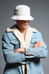 Photo of Fashionable portrait of handsome man in stylish outfit on grey background