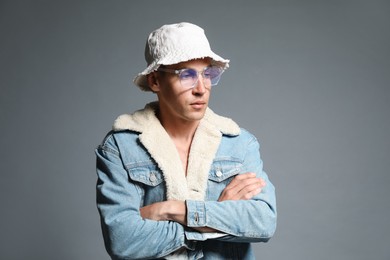 Photo of Fashionable portrait of handsome man in stylish outfit on grey background