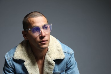 Photo of Fashionable portrait of handsome man in stylish outfit on grey background, space for text