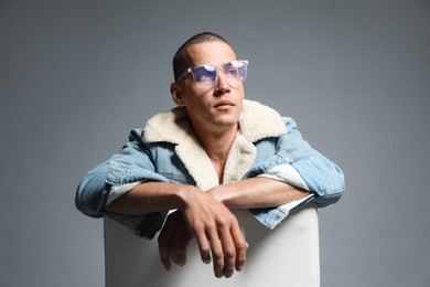 Photo of Fashionable portrait of handsome man in stylish outfit on grey background