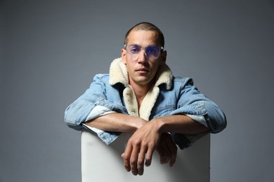 Photo of Fashionable portrait of handsome man in stylish outfit on grey background