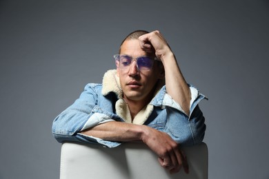 Photo of Fashionable portrait of handsome man in stylish outfit on grey background