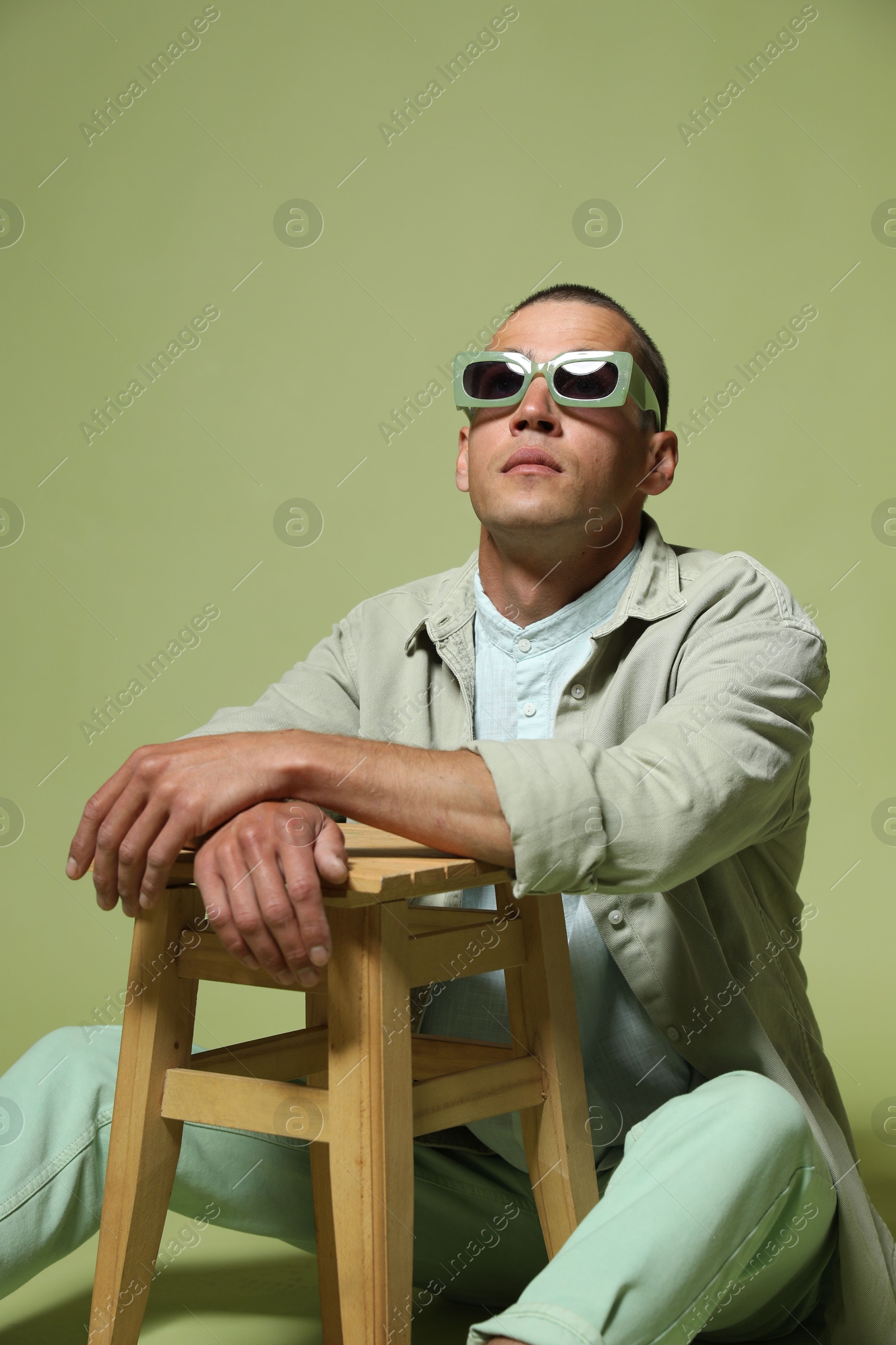 Fashionable portrait of handsome man in stylish outfit on green background Photo of Fashionable portrait of handsome man in stylish outfit on green background