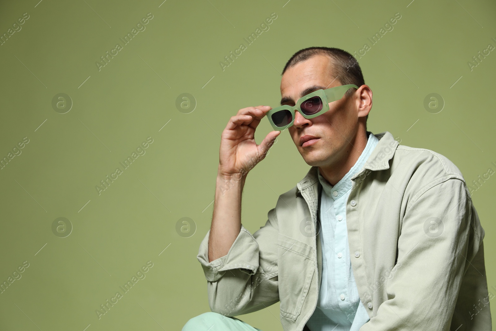 Fashionable portrait of handsome man in stylish outfit on green background, space for text Photo of Fashionable portrait of handsome man in stylish outfit on green background, space for text